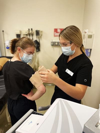 Practical Nursing Students at Brooks Campus learning to wrap a tensor bandage during lab
