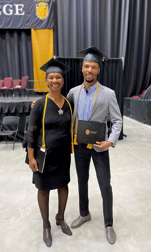 Dian Palmer and Keita Linton, mother and son, standing together in their cap and gown at convocation 