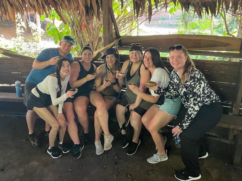 A group of students gather holding small dishes in Costa Rica