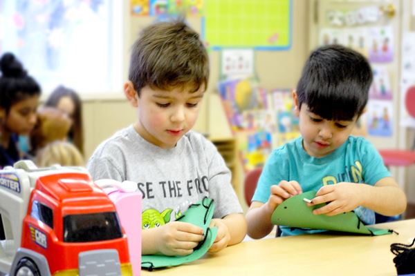 Two children doing crafts at the College Child Development Centre