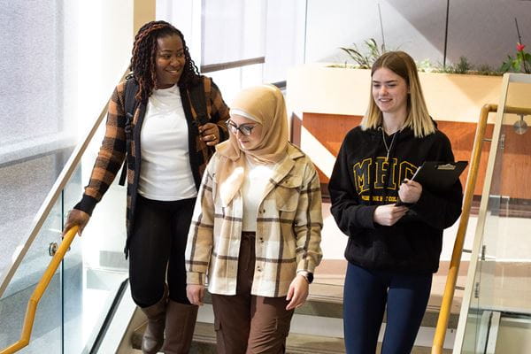 Three students walking down stairs