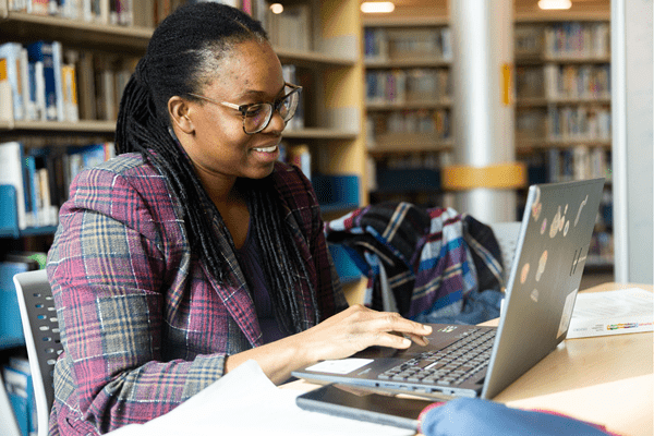 A student working on her laptop in the library