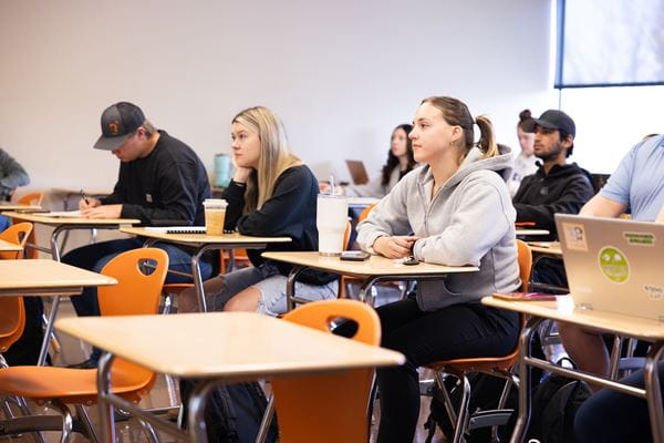 Students sitting at desks in classroom.