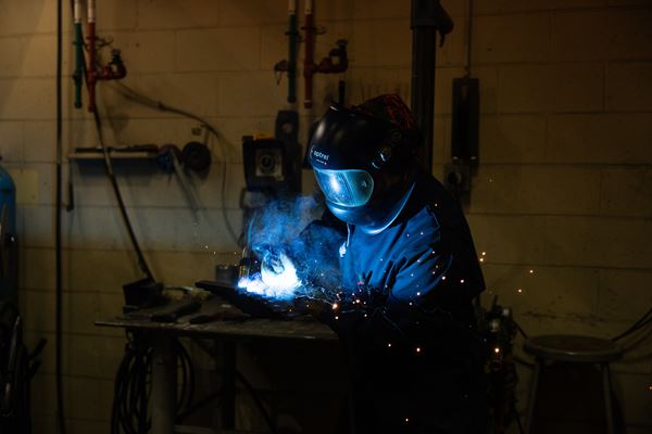 Person welding with sparks flying.