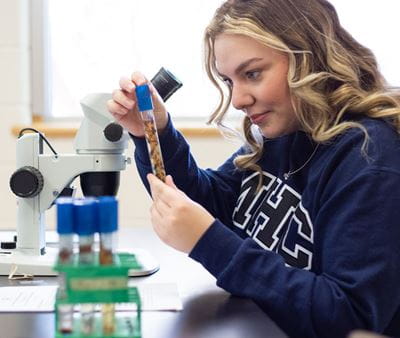 Girl using a microscope in science lab