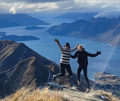 Two students standing on a mountain top above a lake on Education Abroad trip