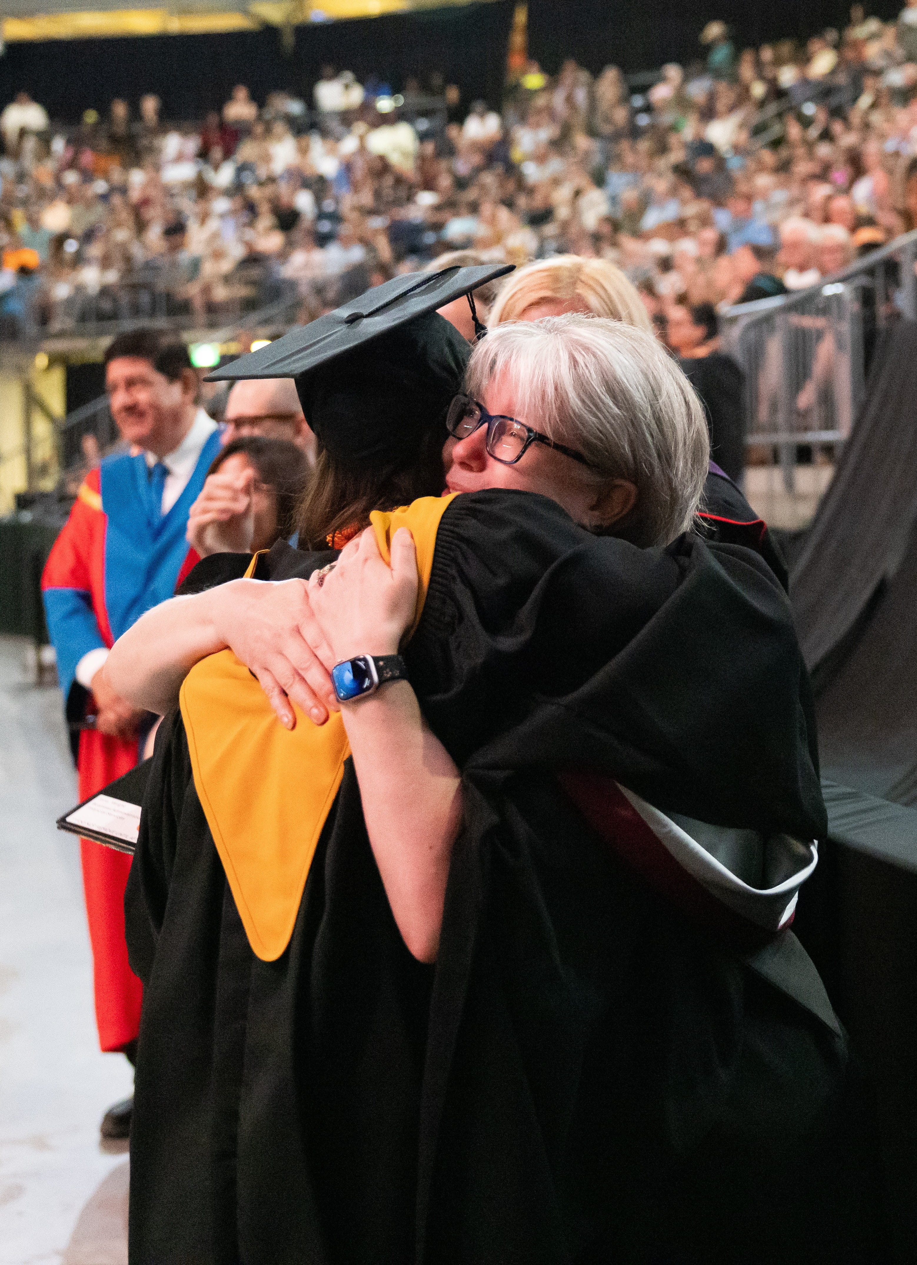 Heather Stahl, Academic Chair of the School of Business and an instructor in the Business Administration and Advanced Accounting, hugs graduate after they come off the stage.