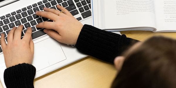 Close up of hands typing on a laptop