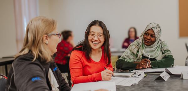 3 women laughing while studying