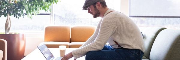 Business student studying on laptop with coffee in business wing. 