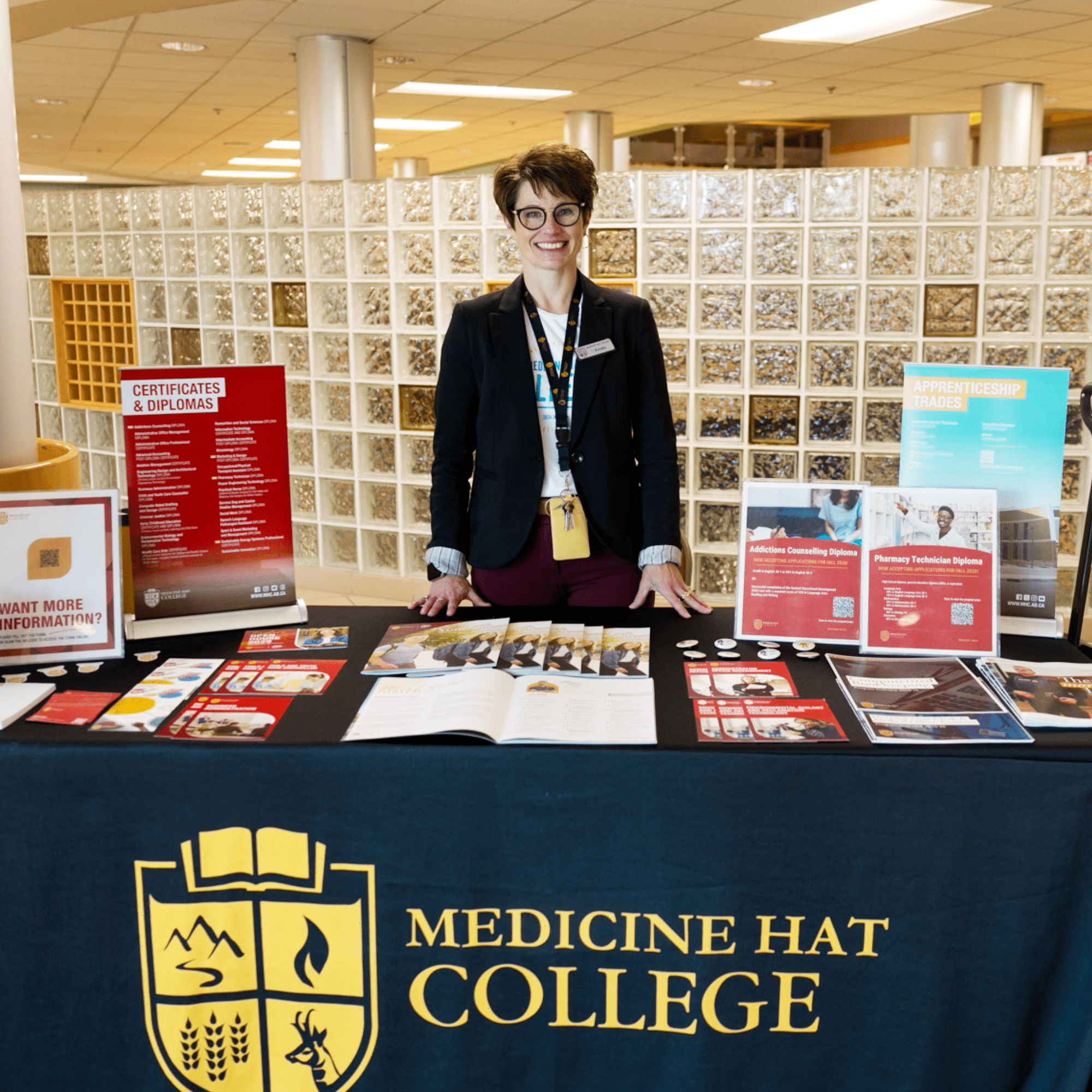 MHC staff member smiling at camera behind table at Carrer Expo. 