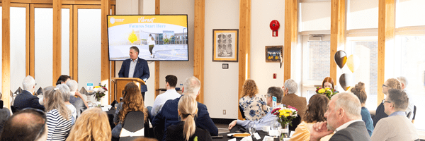 Large group of people watching a presentation by a presenter at an event