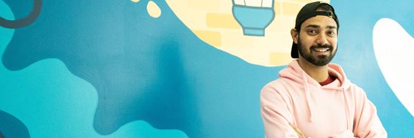 Student standing in front of mural.