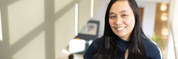 Student standing on stairs, smiling