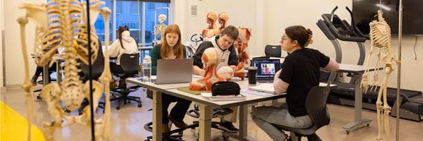 Students studying at a table in the Kinesiology classroom. 