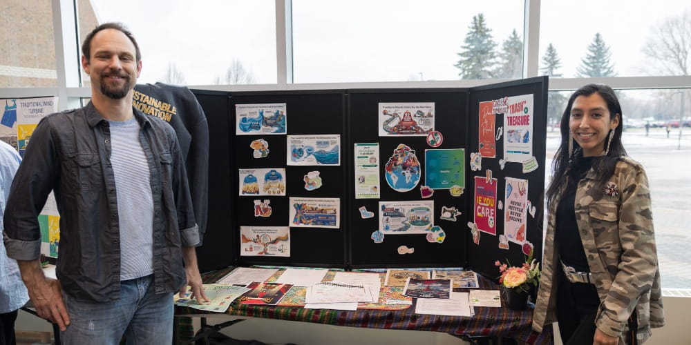 Sustainable Innovation students, Maria Solorzano and David Page standing beside their poster presentation.