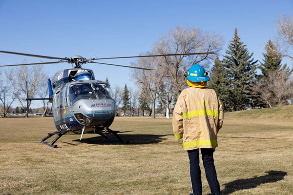 Paramedic student, Ina Old Shoes, stands in front of the HALO Air Ambulance as it lands on Medicine Hat College's north soccer field