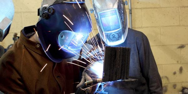 Two students working in the welding lab