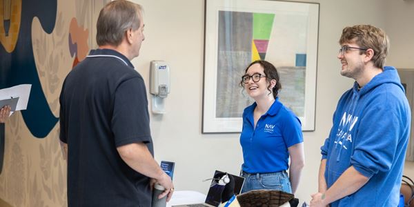 Two employers talking to a student. 