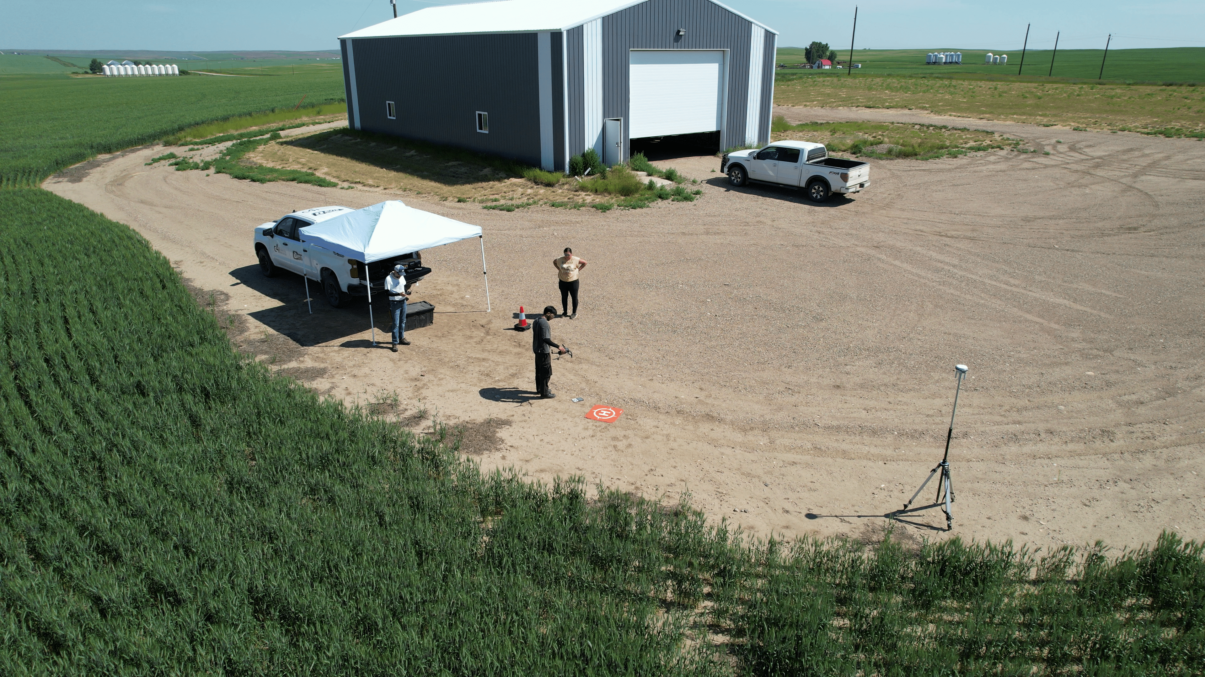 C4i researchers in an agricultural field flying and testing the drone before scanning the land.