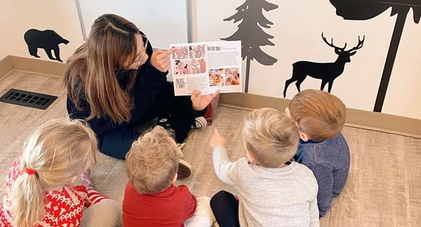 Early Learning & Child Care student, Bianca, reads to four children in her practicum