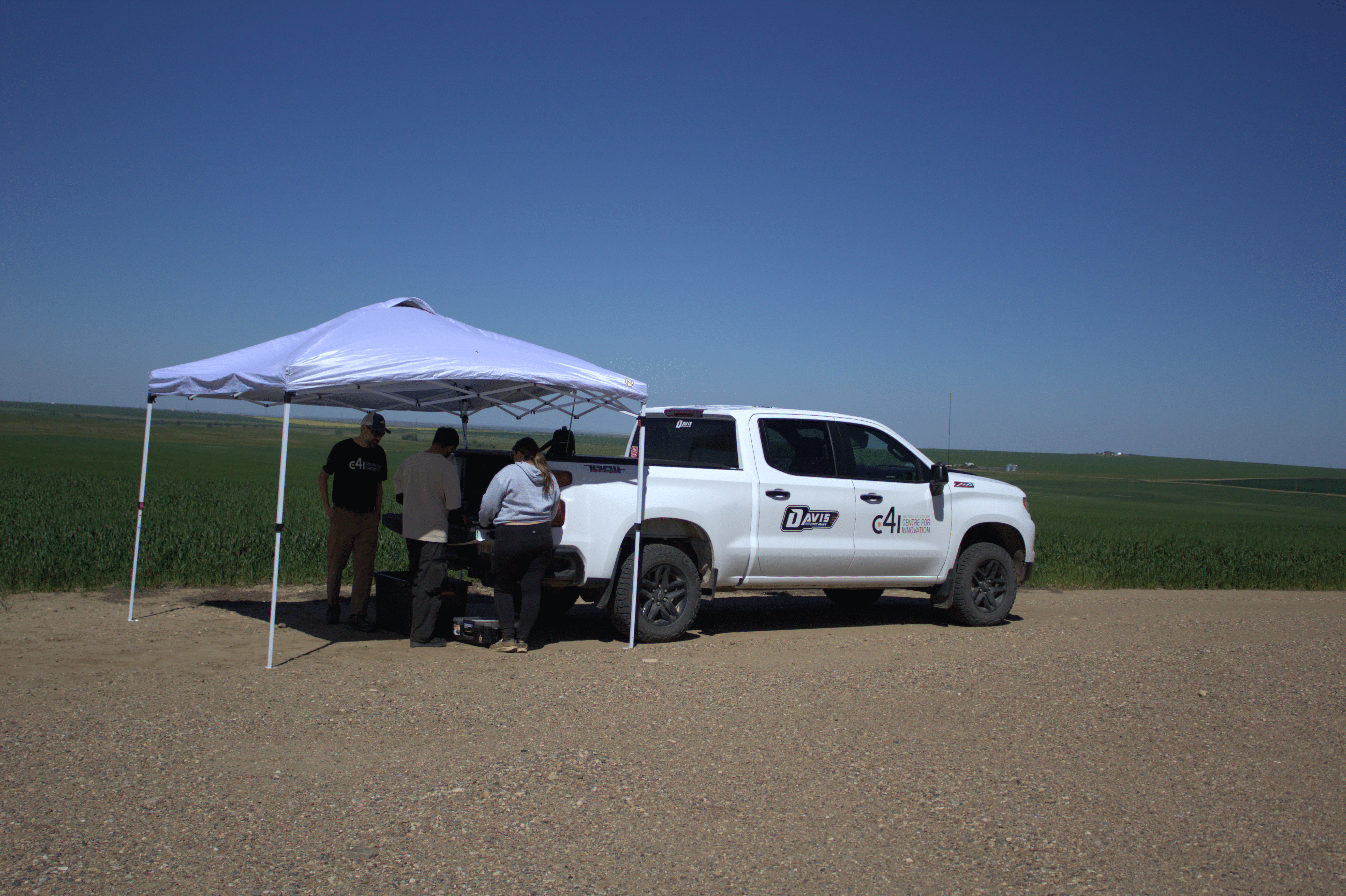 C4i staff at MHC gather equipment from the back of their truck to begin research on agricultural fields.