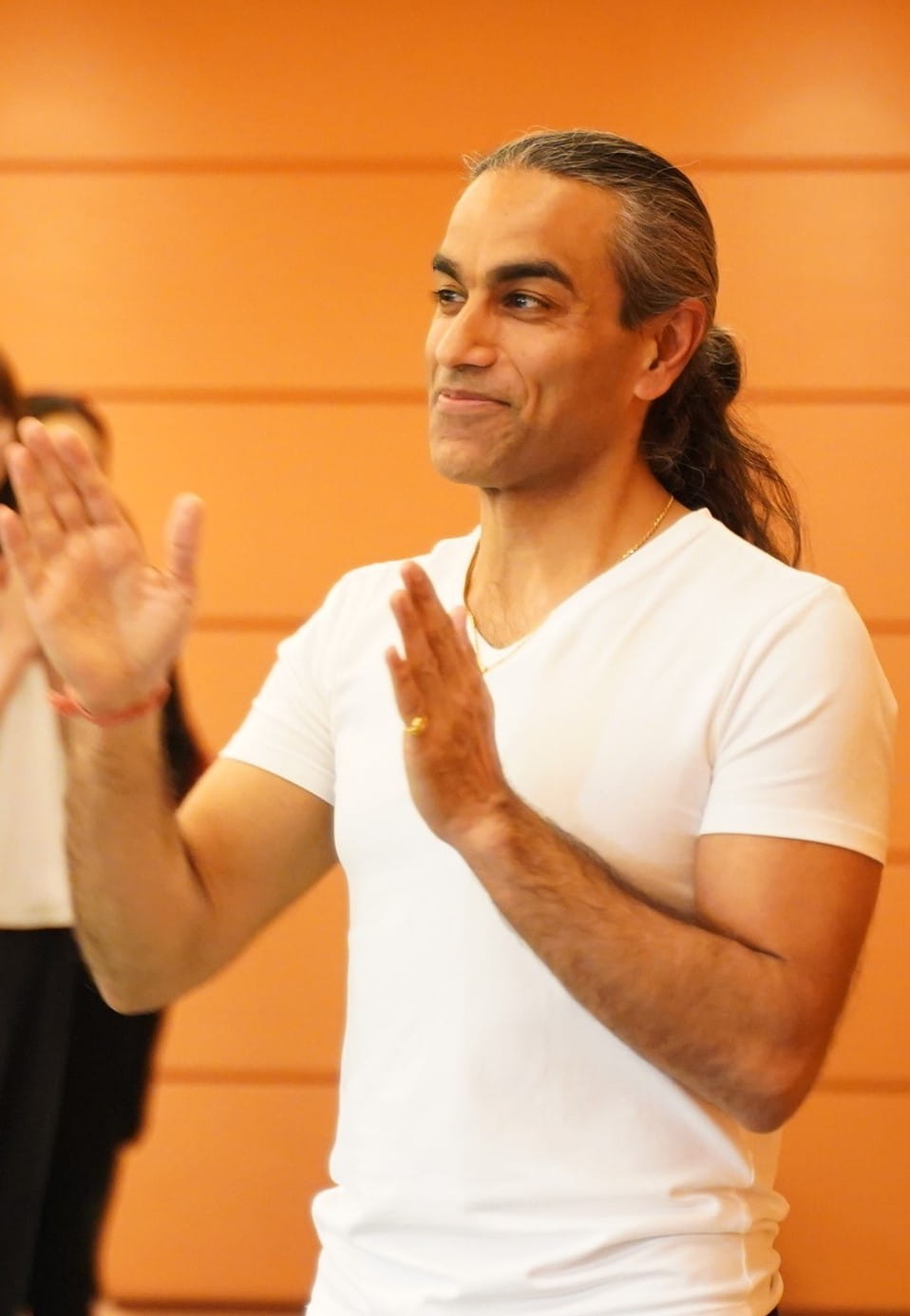 Maneesh Kalra in front of screen, speaking to audience. 