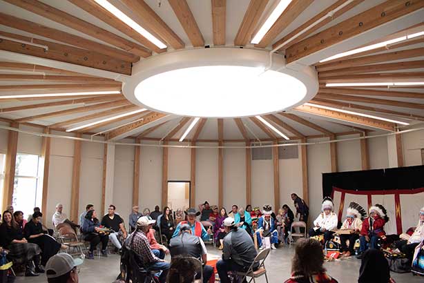 A group of people gathers for a naming ceremony in a circular space