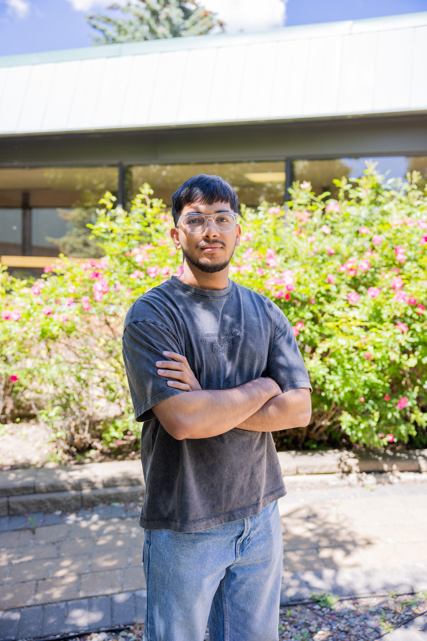 Nitin Nitin, research assistant at C4i, poses in front of greenery with his arms crossed.