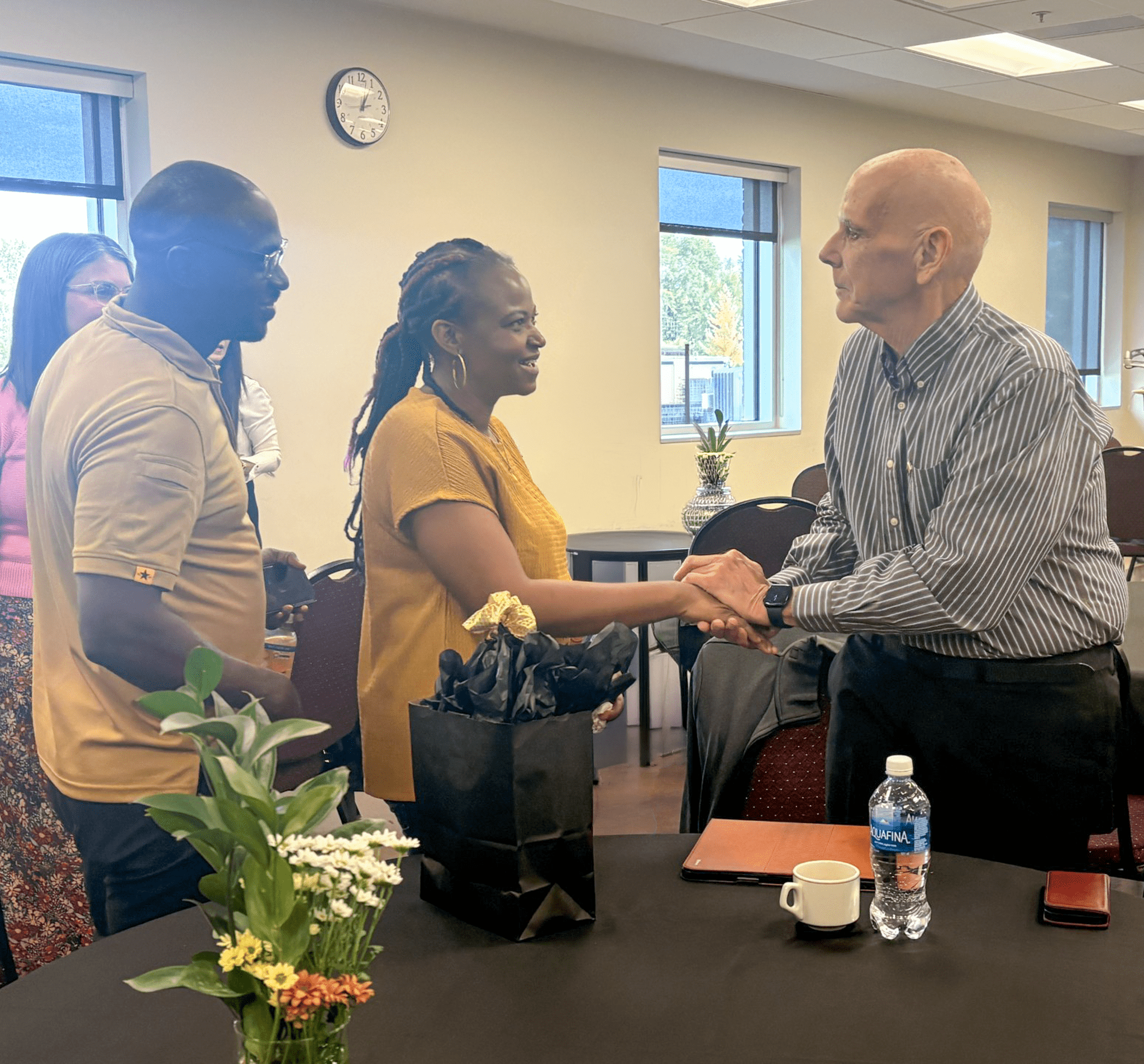 Man shakes woman's hand at an event.