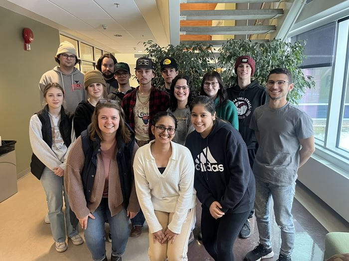 Fourteen sport and event marketing and management students pose for a photo in the F-wing at Medicine Hat College