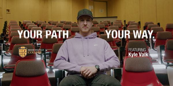 Kyle Valk sitting in lecture classroom - Pathways.