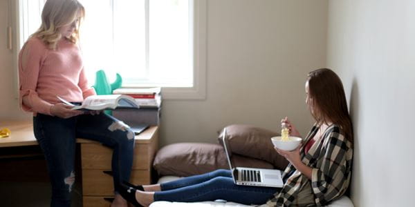 Two girls sitting in residence room