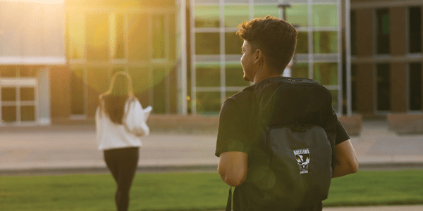 Two students outside of Medicine Hat College, walking towards the front entrance