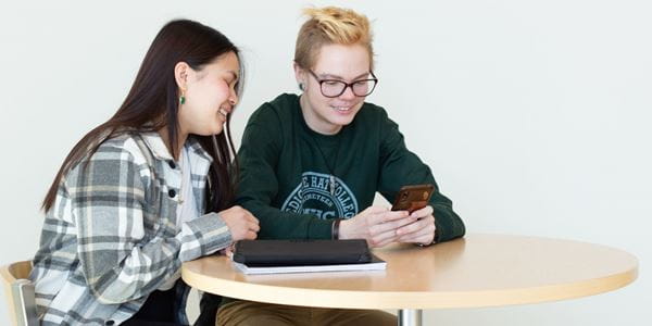 Two students looking at a cell phone