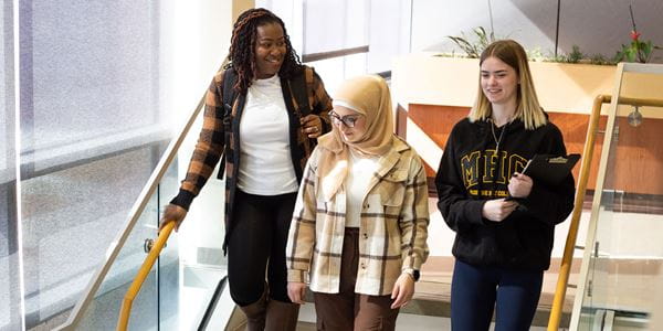 Three students walking down stairs.