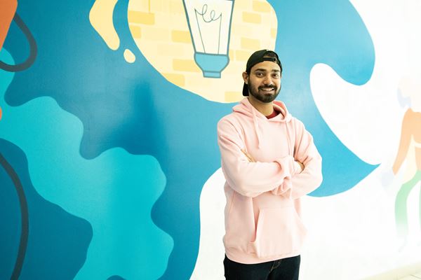 Student standing in front of bright painted wall mural